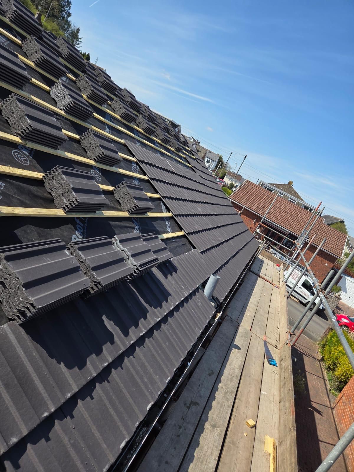 Tiles loaded out on new battens and membrane during a re-roof in Heolgerrig