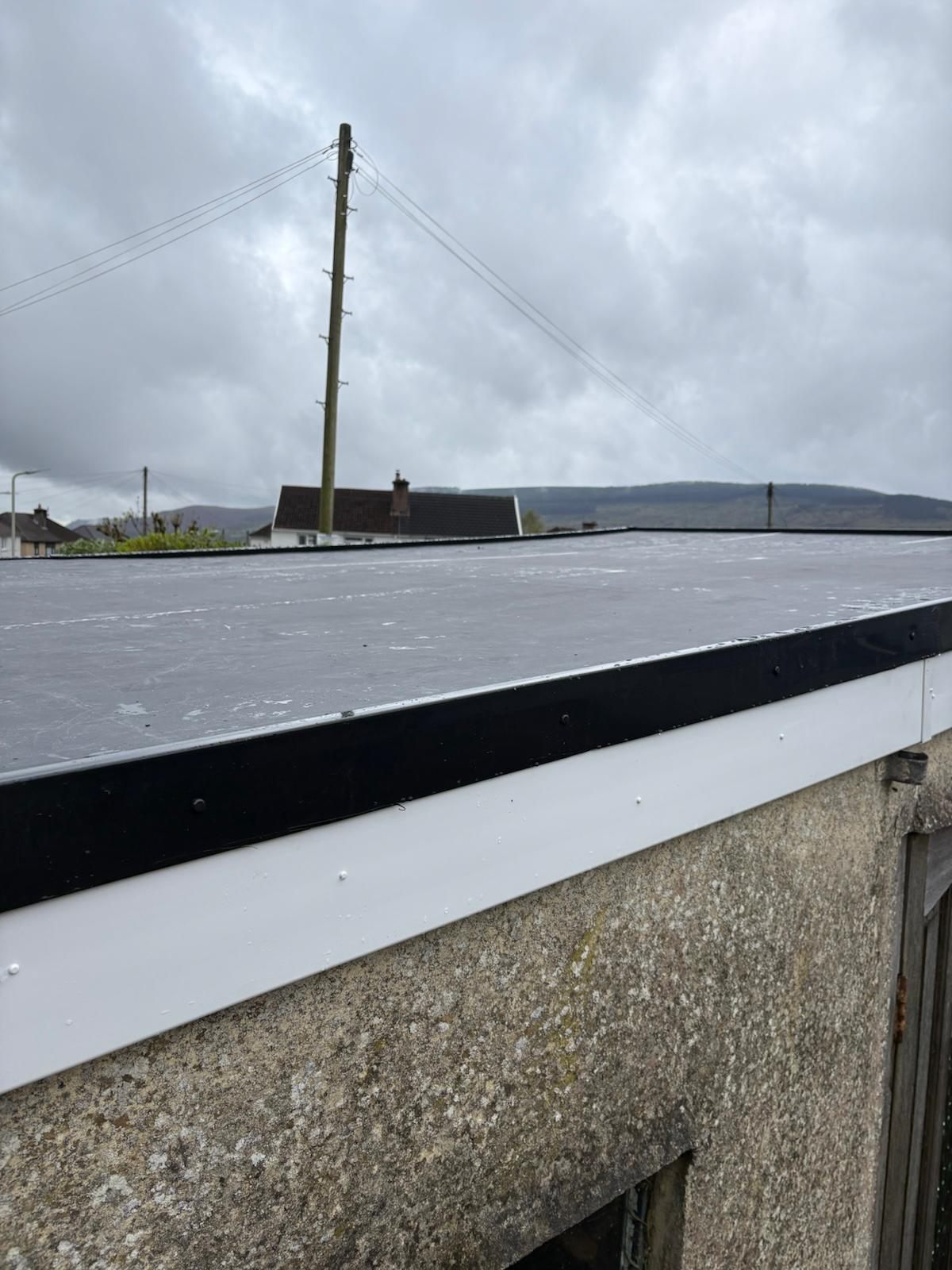 Close-up of new rubber roof edge trim and white fascia in Twynyrodyn, Merthyr Tydfil