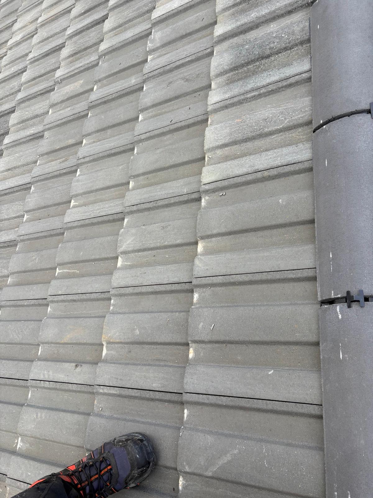 Close-up of new grey interlocking roof tiles and mechanically fixed dry ridge in Cwm, Ebbw Vale